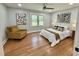 Comfortable bedroom featuring stylish artwork, a ceiling fan, and natural light from a large window at 131 Rosewood Dr Dr, Roxboro, NC 27573