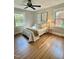 Bright bedroom featuring hardwood flooring, ceiling fan, and multiple windows at 131 Rosewood Dr Dr, Roxboro, NC 27573