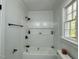 Bright bathroom with white tile, a shower and tub combo, and a built-in shelf at 1336 Hill St, Rocky Mount, NC 27801