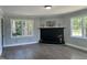 Inviting living room with a black fireplace, two windows, and gray wainscoting at 1336 Hill St, Rocky Mount, NC 27801