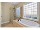 Bright bathroom with a glass enclosed shower, large soaking tub, and a window letting in plenty of natural light at 134 Barclay Valley Dr, Cary, NC 27519