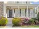 Charming front porch with white columns, detailed railings, and colorful flowerbeds enhancing curb appeal at 134 Barclay Valley Dr, Cary, NC 27519