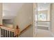 Bright upstairs hallway featuring wood railing, a decorative light fixture, and neutral colored paint and carpet at 134 Barclay Valley Dr, Cary, NC 27519