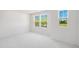 Bright bedroom with white walls, plush carpeting, and windows overlooking lush green trees at 1533 Crescent Townes Way, Raleigh, NC 27604
