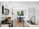 Open kitchen showcases white cabinets, stainless steel appliances, and an adjacent dining area at 1533 Crescent Townes Way, Raleigh, NC 27604