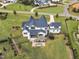 A luxurious home featuring an expansive backyard with mature trees, a stone patio, and play area at 1633 Estate Valley Ln, Raleigh, NC 27613