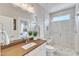 Modern bathroom featuring glass shower with a bench, with a light brown vanity, and mirror at 1633 Estate Valley Ln, Raleigh, NC 27613