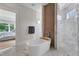 This bright bathroom features a freestanding tub, marble tile, and a seamless glass shower at 1633 Estate Valley Ln, Raleigh, NC 27613