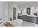 This bright bathroom features a freestanding tub and gray vanity with a modern mirror and lighting at 1633 Estate Valley Ln, Raleigh, NC 27613