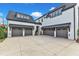 Expansive concrete driveway leading to multiple car garages in a modern home with black trim and white brick at 1633 Estate Valley Ln, Raleigh, NC 27613