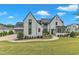 Stunning two-story home with a white brick facade, elegant dark trim, and a meticulously manicured lawn at 1633 Estate Valley Ln, Raleigh, NC 27613
