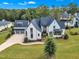 Aerial view of luxury home showing the front exterior with a long driveway and lush landscaping at 1633 Estate Valley Ln, Raleigh, NC 27613