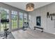 Bright home gym featuring workout equipment, hardwood floors, large windows, and paneled walls at 1633 Estate Valley Ln, Raleigh, NC 27613
