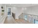 Hallway boasts hardwood floors, iron-railed staircase, laundry access, and an ornate chandelier at 1633 Estate Valley Ln, Raleigh, NC 27613