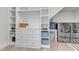 Well-lit walk-in closet with washer and dryer hookups, custom shelving, drawers, and ample storage space at 1633 Estate Valley Ln, Raleigh, NC 27613