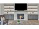 A modern living room with fireplace boasts white stone walls, recessed lighting, built-in shelves and cabinets at 1633 Estate Valley Ln, Raleigh, NC 27613