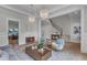 Stylish living room with hardwood floors, chandeliers, modern furnishings, and seamless transition to the staircase at 1633 Estate Valley Ln, Raleigh, NC 27613