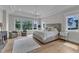This spacious main bedroom has an elegant tray ceiling, a chandelier, and large windows offering views of the outdoors at 1633 Estate Valley Ln, Raleigh, NC 27613