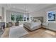This spacious main bedroom has an elegant tray ceiling, a chandelier, and large windows offering views of the outdoors at 1633 Estate Valley Ln, Raleigh, NC 27613