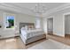 This spacious main bedroom features a tray ceiling, a chandelier, and a view of an ensuite bathroom at 1633 Estate Valley Ln, Raleigh, NC 27613