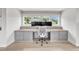 Bright home office with built-in desk, drawers, hardwood floors, and three monitors at 1633 Estate Valley Ln, Raleigh, NC 27613