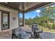 Inviting covered patio featuring stone floors, comfortable seating, and scenic views of the backyard at 1633 Estate Valley Ln, Raleigh, NC 27613