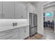 A modern pantry boasts white countertops, ample cabinet space, stainless steel refrigerator and appliances for storage at 1633 Estate Valley Ln, Raleigh, NC 27613