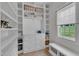 Bright walk-in closet features custom shelving, drawers, and a window with a bench seat at 1633 Estate Valley Ln, Raleigh, NC 27613