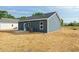 Home exterior with blue siding, a back patio, and a neatly maintained yard at 19 Southern Village Dr, Roxboro, NC 27573