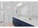 Bathroom featuring double sinks, quartz countertops, navy cabinets, and glass enclosed shower at 19 Southern Village Dr, Roxboro, NC 27573