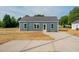 View of single story home featuring a concrete driveway and minimalist landscaping at 19 Southern Village Dr, Roxboro, NC 27573