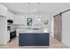 Modern kitchen with white cabinets, granite countertops, a navy island, and a sliding barn door at 19 Southern Village Dr, Roxboro, NC 27573
