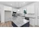 Bright kitchen featuring white cabinetry, stainless steel appliances, and a granite countertop island at 19 Southern Village Dr, Roxboro, NC 27573