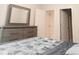 Comfortable bedroom with a gray dresser, large mirror, and a cozy bedspread at 2089 Florine Dr, Apex, NC 27502