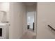 Hallway leading to bedroom and laundry room with white trim, carpet, and modern appliances at 2089 Florine Dr, Apex, NC 27502