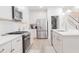 Well-lit kitchen showcasing stainless steel appliances, white cabinets, a spacious pantry, and a quartz countertop at 2089 Florine Dr, Apex, NC 27502