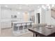Bright kitchen featuring white cabinets, stainless steel appliances, an island with bar seating, and a modern pendant lighting fixture at 2089 Florine Dr, Apex, NC 27502