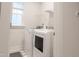 Bright laundry room with modern appliances including a front-loading washer and dryer with window at 2089 Florine Dr, Apex, NC 27502