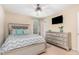 Spacious bedroom featuring a silver-framed bed, ceiling fan, mounted TV, and dresser at 2112 Ballston Pl, Knightdale, NC 27545