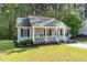 Single-story home featuring a welcoming front porch with comfortable seating and manicured lawn at 2112 Ballston Pl, Knightdale, NC 27545