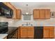 Well-lit kitchen area showcasing wooden cabinets, black appliances, and countertop space at 2112 Ballston Pl, Knightdale, NC 27545