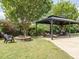 Landscaped backyard featuring a gazebo, fire pit, lounge chairs, and lush greenery at 212 Listening Ridge Ln, Cary, NC 27519