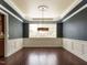 Elegant dining room featuring dark wood floors, wainscoting, and a decorative ceiling with modern lighting at 212 Listening Ridge Ln, Cary, NC 27519