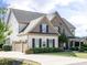 Beautiful home with a three car garage, manicured lawn, and decorative fountain at 212 Listening Ridge Ln, Cary, NC 27519