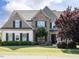 Charming two-story home featuring brick and siding exterior, manicured lawn, and mature landscaping at 212 Listening Ridge Ln, Cary, NC 27519