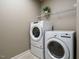 Well-lit laundry room featuring modern appliances, shelving, and neutral walls at 212 Listening Ridge Ln, Cary, NC 27519