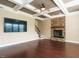 Inviting living room with coffered ceiling, hardwood floors, a stone fireplace, and a large TV at 212 Listening Ridge Ln, Cary, NC 27519