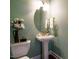 Stylish powder room featuring designer wallpaper, pedestal sink, and decorative accents at 212 Listening Ridge Ln, Cary, NC 27519