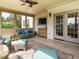 Bright sunroom featuring stylish wicker furniture, tile flooring, and sliding doors to the outside at 212 Listening Ridge Ln, Cary, NC 27519