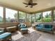 Relaxing sunroom features comfortable wicker furniture, ceiling fan, and scenic outdoor views at 212 Listening Ridge Ln, Cary, NC 27519
